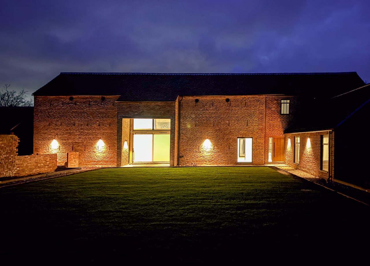 Exterior lighting installation on a brick property at dusk